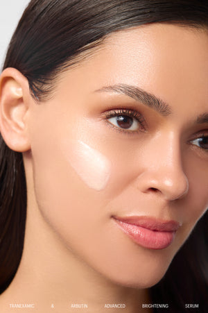 Model with a swipe of Tranexamic & Arbutin Brightening Serum on cheek
