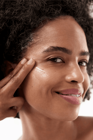 Close-up of model applying GF Advanced Lifting Serum to her face
